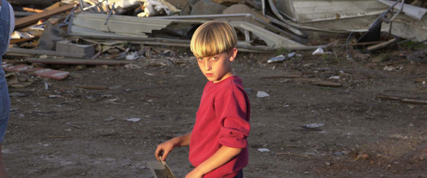 A child walks past the remains of his home which was destroyed by a tornado.